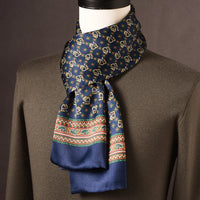 Marineblauwe zijden sjaal met gouden motieven en een gekleurde sierrand met paisleys, op een paspop met olijfgroene trui. 20