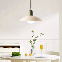 Hanglamp met groene fitting en crèmekleurige kap boven een witte tafel met druiven, citroen en glas 6