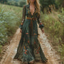 Model in groene maxi-jurk met geborduurde bloemen en bruine strikriem op een zandpad 1