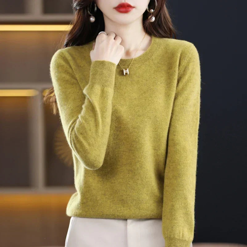 Model in een mosgroene trui met ronde hals, een hand tegen de hals 13
