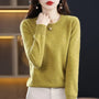 Model in een mosgroene trui met ronde hals, een hand tegen de hals 13