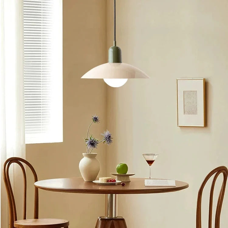 Hanglamp met groene fitting en lichte kap boven een houten tafeltje bij een raam 9