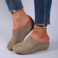 Beige pantoffels gedragen door een model met kralenarmband om de enkel, zijaanzicht met stiksels en uitsparing in de zool. 3
