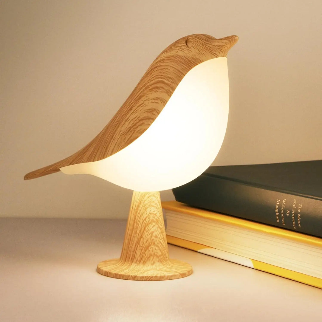 Brandende vogellamp met houtlook en lichtgevende witte buik naast een stapel boeken 1