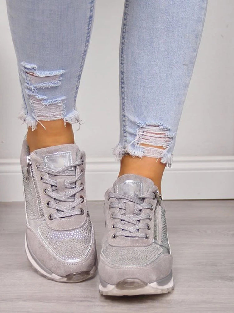 Grijze sneakers met veters en strass, van voren gezien aan de voeten van een model 6