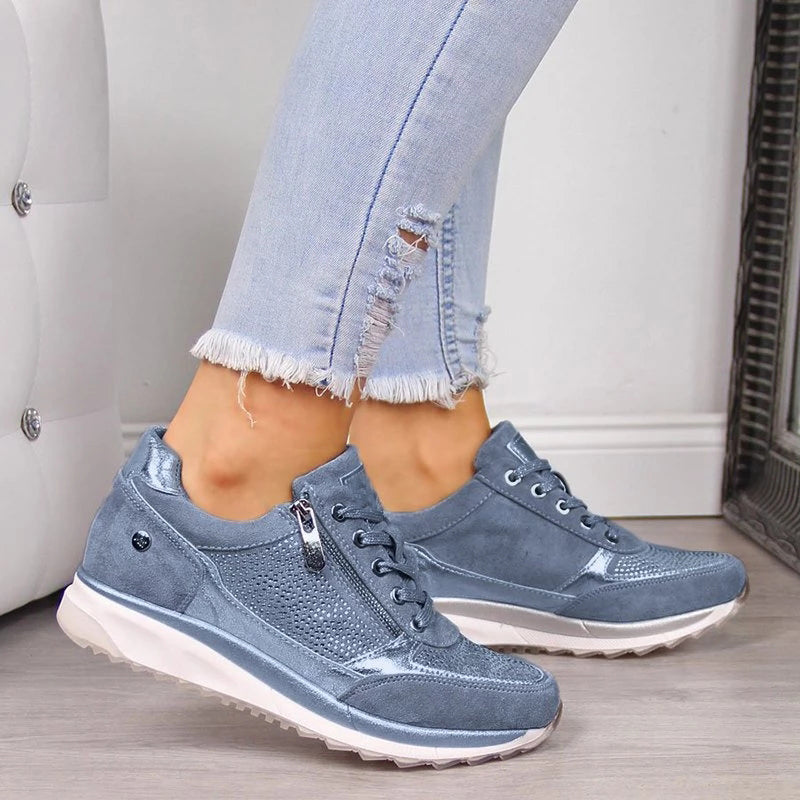 Blauwe sneakers met rits en glinsterende steentjes, zijaanzicht gedragen onder een gerafelde spijkerbroek 3