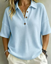 Voorkant van het lichtblauwe wafelpoloshirt met korte mouwen en knoopjes, gedragen door een model 6