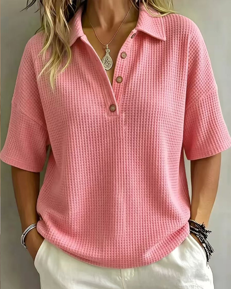 Voorkant van het roze wafelpoloshirt met korte mouwen en knoopjes, gedragen door een model 9