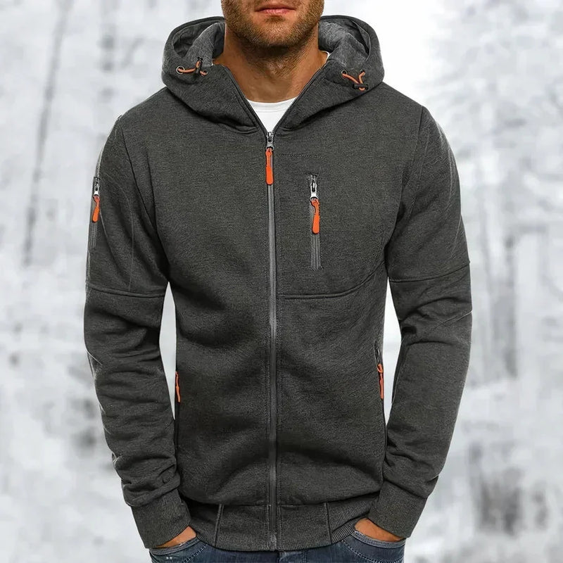 Donkergrijze gemêleerde hoodie met oranje ritstrekkers en capuchon met trekkoord, gedragen door een man in een winterse omgeving. 9