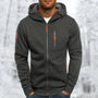 Donkergrijze gemêleerde hoodie met oranje ritstrekkers en capuchon met trekkoord, gedragen door een man in een winterse omgeving. 9