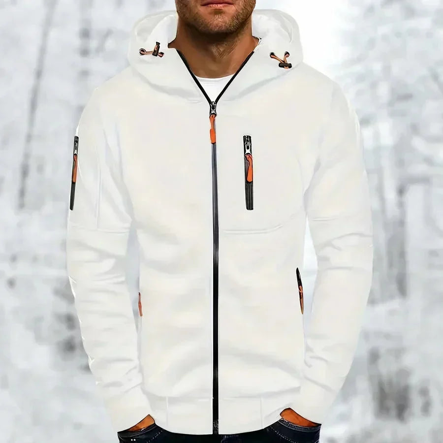 Man in de witte hoodie met oranje ritstrekkers en zwarte rits, borstzakje en mouwzakje zichtbaar, tegen een sneeuwachtergrond. 3