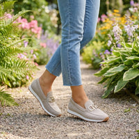 Beige instappers gedragen tijdens een wandeling over een grindpad in een bloeiende tuin 11