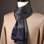 Marineblauwe sjaal met klein paisleypatroon en effen onderkant, gedrapeerd om een pop met beige trui. 26