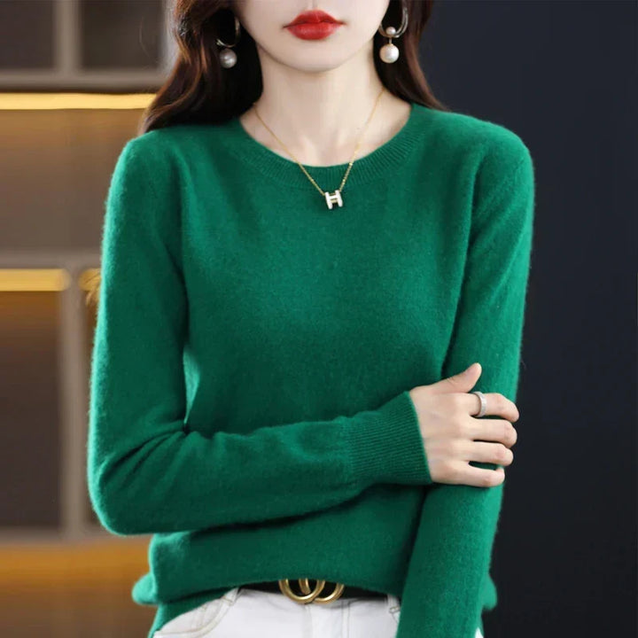 Model in een groene trui met ronde hals, de armen voor het lichaam gekruist 6