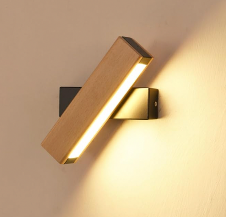 Close-up van de brandende houten lamp met zwarte steun, schuin gedraaid, met warm licht dat langs de muur valt. 7