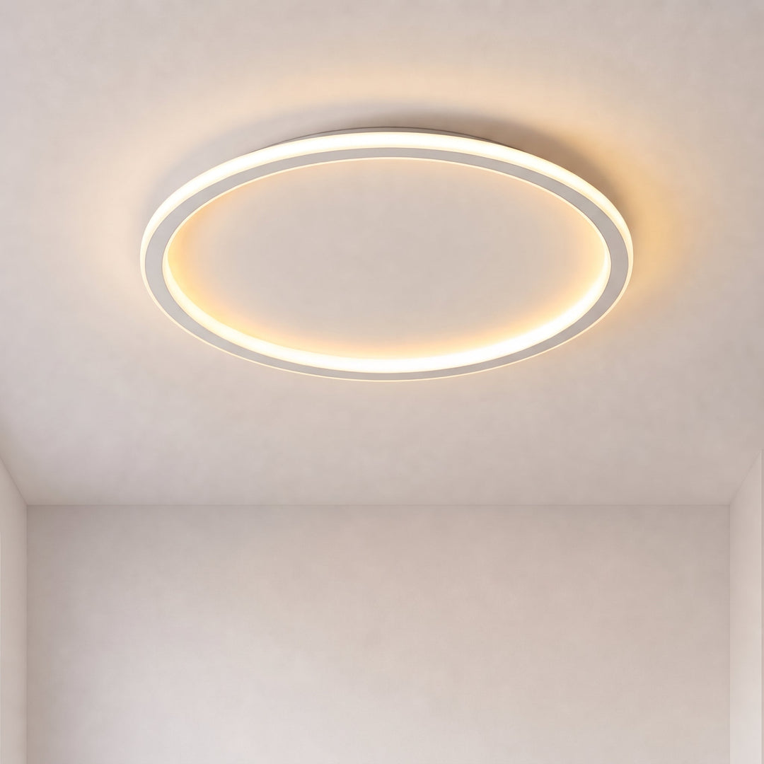 Aangezette ronde plafondlamp met een lichtgevende ring tegen een kaal plafond, hoekperspectief in een lege kamer met warm licht. 1