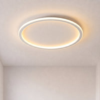 Aangezette ronde plafondlamp met een lichtgevende ring tegen een kaal plafond, hoekperspectief in een lege kamer met warm licht. 1