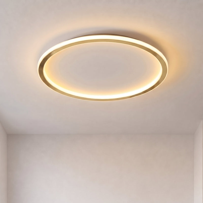 Brandende ronde plafondlamp met gouden rand en warm licht tegen een kaal wit plafond 1