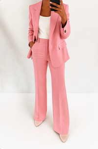 Model in het roze broekpak met wit topje en lichte pumps, hand in de broekzak 5