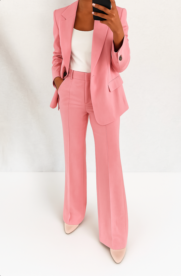 Model in het roze broekpak met wit topje en lichte pumps, hand in de broekzak 5