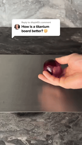 Hand rolt een rode ui over het donkere, effen oppervlak van de plank, met een vraag uit een videoreactie erboven. 5