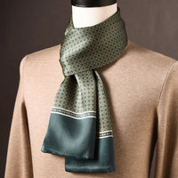 Groene zijden sjaal met kleine bloemachtige cirkelmotieven en brede groene rand, op een paspop met beige trui. 8