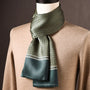 Groene zijden sjaal met kleine bloemachtige cirkelmotieven en brede groene rand, op een paspop met beige trui. 8