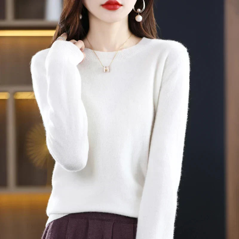 Model in een witte trui met ronde hals, gedragen met een donkere plooirok 7