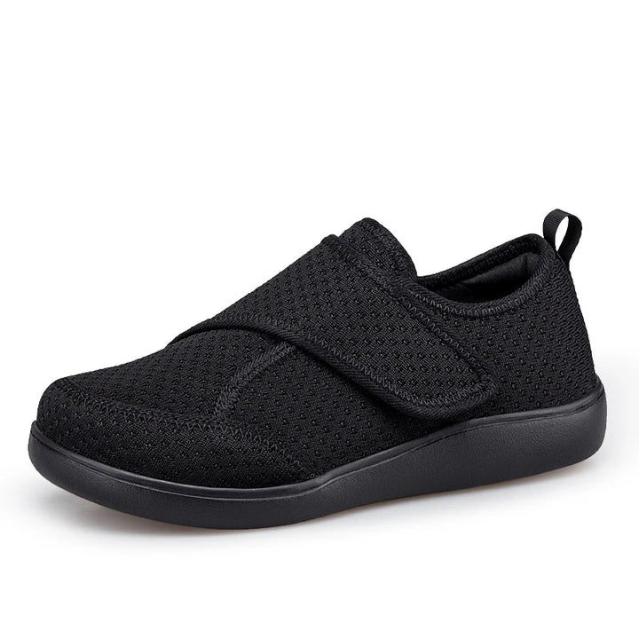 Zwarte mesh schoen met klittenbandsluiting en zwarte zool, schuin van opzij gezien 1