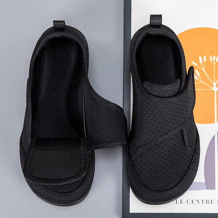 Bovenaanzicht van twee zwarte schoenen, een met geopend klittenband en zwarte binnenzool 7