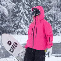Model in felroze ski-jack met capuchon houdt een snowboard vast, tegen een achtergrond van besneeuwde bomen. 5