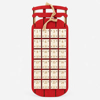 Rode houten sleekalender van voren, met 24 genummerde laatjes, houten knopjes en een strik van jutetouw, op een witte achtergrond. 5