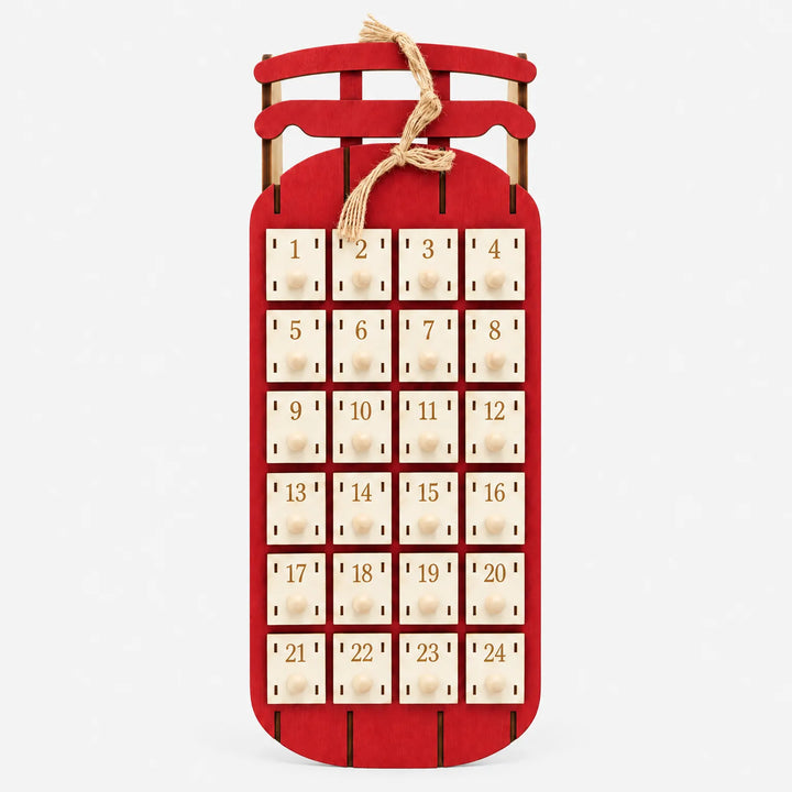 Rode houten sleekalender van voren, met 24 genummerde laatjes, houten knopjes en een strik van jutetouw, op een witte achtergrond. 5