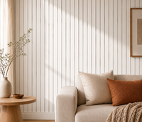 Close-up van witte latwand naast een bank met kussens, vaas met takken en ronde bijzettafel 11