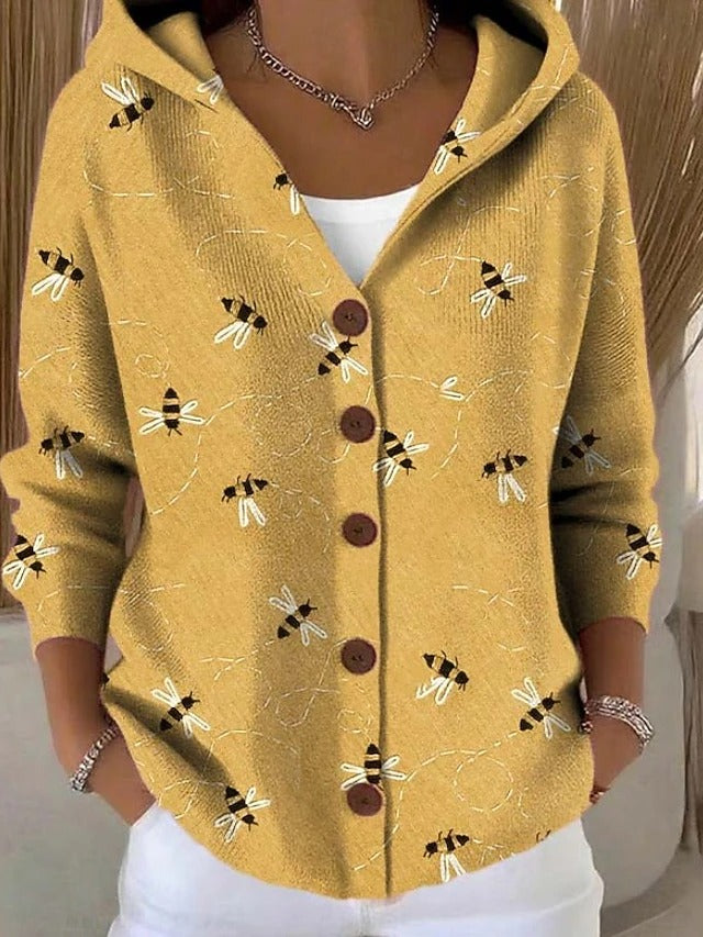 Vooraanzicht op model: gele hoodie met knopen en een print van kleine bijtjes met gestippelde vliegroutes. 2