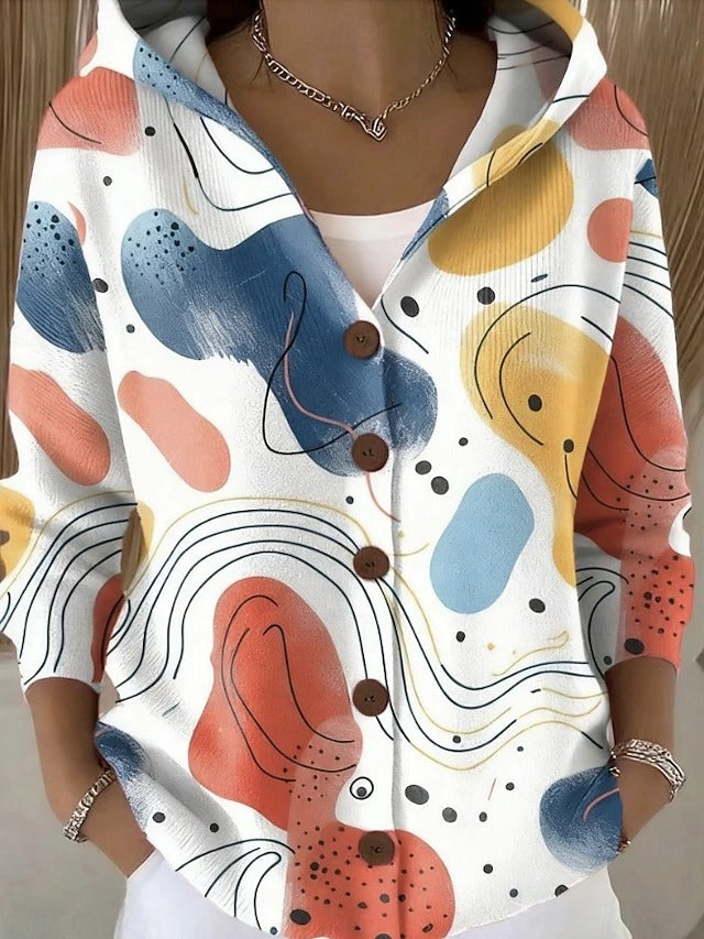 Vooraanzicht op model: witte hoodie met knopen en abstracte print van pastelkleurige vlekken en golvende lijnen in blauw, oranje en geel. 3