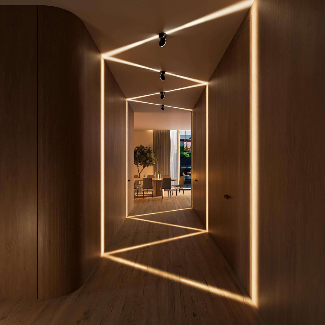 Zwarte plafondlampen in een houten gang werpen zigzaglijnen van warm licht over plafond, wanden en vloer, met een eettafel aan het einde. 10