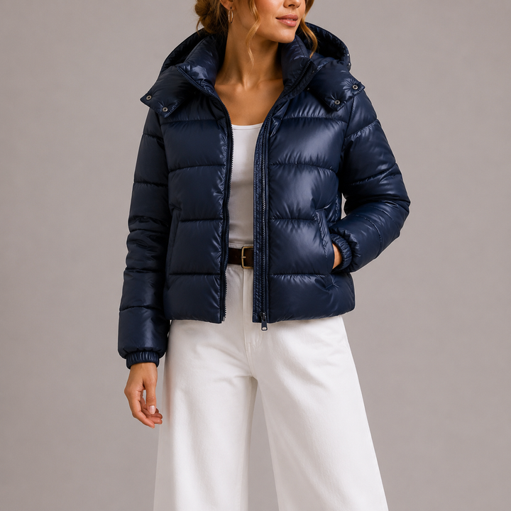 Marineblauw gewatteerd jack half open gedragen over wit topje en witte broek, vooraanzicht met capuchon 2