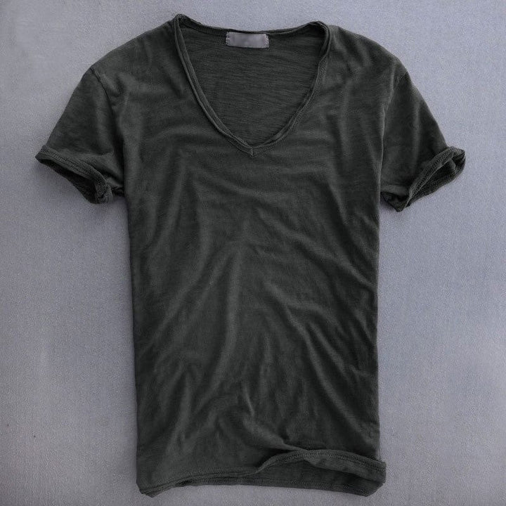 Voorkant van het shirt in donkergrijs op een grijze ondergrond, met V-hals en een lichte, slubbige stofstructuur. 4