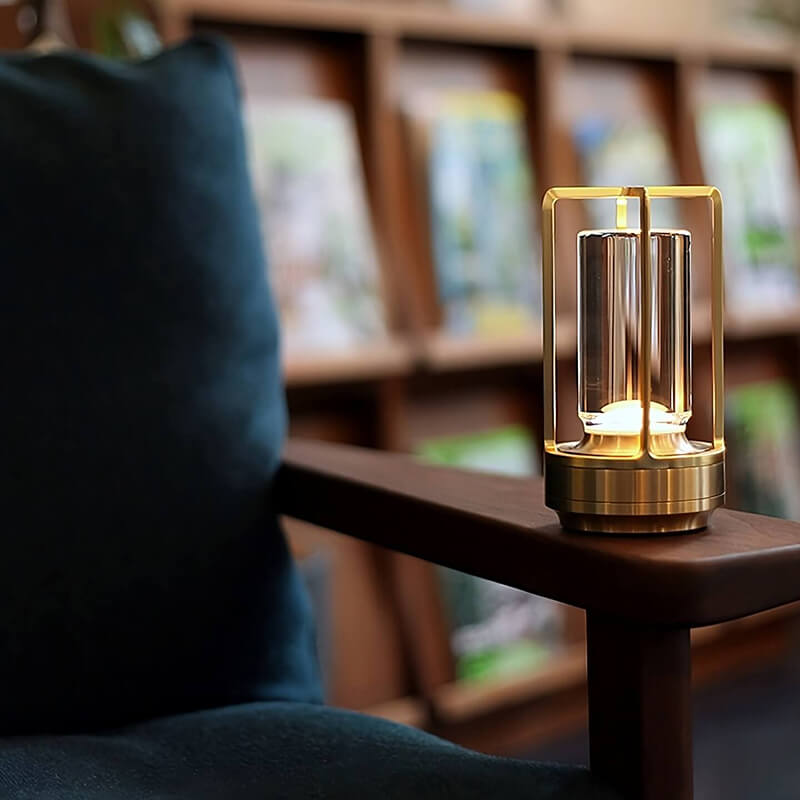 Goudkleurige lamp brandt op de houten armleuning van een stoel, met een boekenkast op de achtergrond. 8