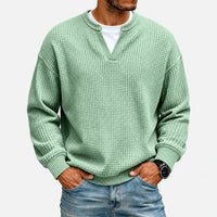 Lichtgroen wafelshirt gedragen door een model met een wit shirt eronder, tegen een witte achtergrond 2