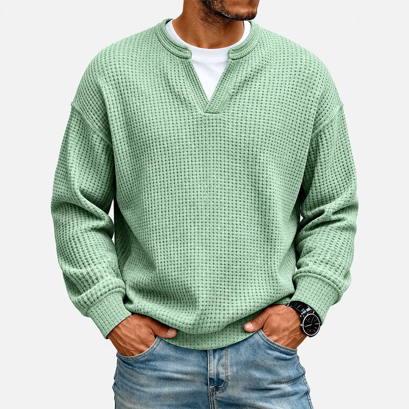 Lichtgroen wafelshirt gedragen door een model met een wit shirt eronder, tegen een witte achtergrond 2