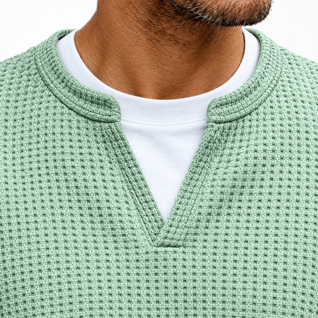 Close-up van de ingesneden V-hals in wafelstructuur, met een wit shirt eronder voor het gelaagde effect 3