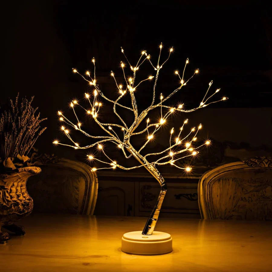 Verlichte boomlamp met warme lampjes op een tafel naast een vaas met gedroogde bloemen 2