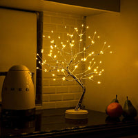 Brandende boomlamp op een keukenblad naast een waterkoker en twee peren met een sinaasappel 5