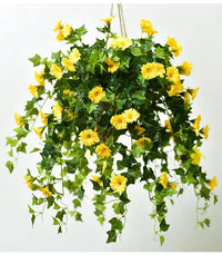 Hangende bos gele kunstbloemen met donkergroene klimopbladeren aan touwen, gefotografeerd tegen een lichte achtergrond. 2