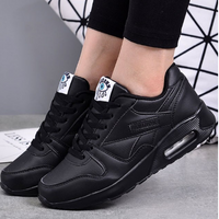 Zwarte sneakers met luchtkussenzool gedragen door een model, met zwarte legging en geometrisch patroon op de achtergrond 2