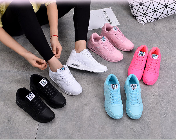 Sneakers in zwart, wit, roze, felroze en lichtblauw bij elkaar, terwijl een model een veter strikt 4