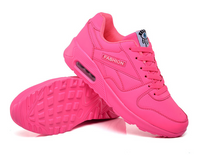 Felroze sneaker van opzij met de gegroefde zool zichtbaar ernaast, op witte achtergrond 7
