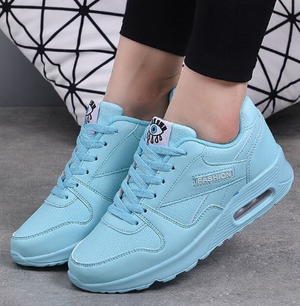 Lichtblauwe sneakers met veters en luchtkussenzool, gedragen door een model met zwarte legging 8
